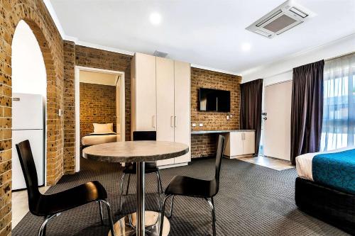 
a living room with a dining room table and chairs at Comfort Inn & Suites Manhattan in Adelaide
