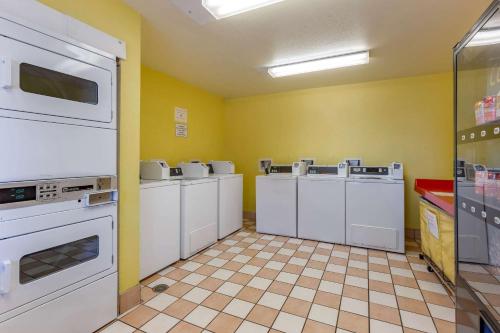 a kitchen with a row of washers and dryers at Suburban Studios Albuquerque Uptown in Albuquerque