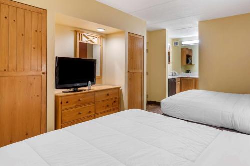 a bedroom with two beds and a flat screen tv at Econo Lodge Pigeon Forge Riverside in Pigeon Forge