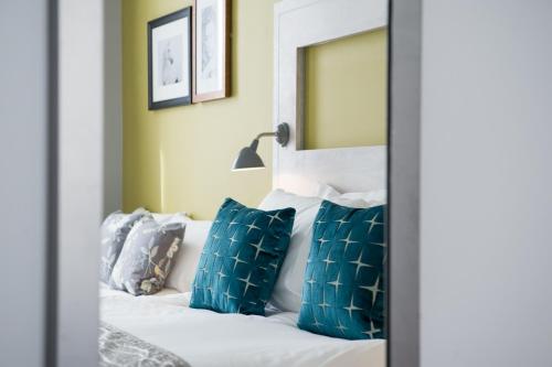 a bedroom with a bed with blue and white pillows at The Hedgehog by Innkeeper's Collection in Lichfield
