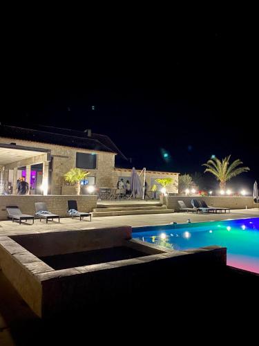 - une piscine avec des chaises la nuit et un bâtiment dans l'établissement VILLA DEL CASTAGNOL, à Saint-Nexans