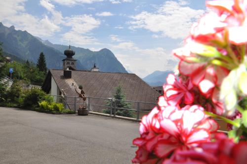 a building with a church with mountains in the background at Appartement Rietli in Triesenberg