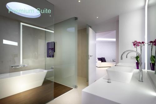 a bathroom with a tub and a sink and a toilet at Hotel Garbi Ibiza & Spa in Playa d'en Bossa