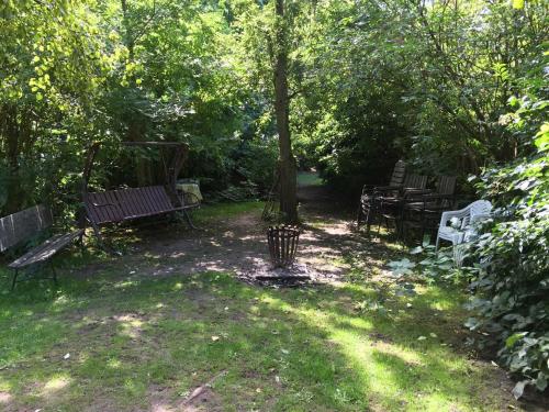 a group of park benches sitting under a tree at Ferienhaus 1 _ Ferien im Gutspark in Mattchow