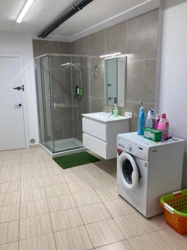 a bathroom with a shower and a washing machine at Villa Sol in Callao Salvaje