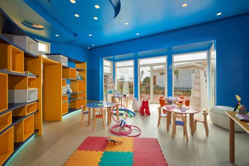 a childrens room with blue walls and tables and chairs at Radisson Blu Resort Saidia Beach in Saidia 