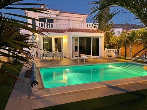 a villa with a swimming pool in front of a house at Villa Sol in Callao Salvaje