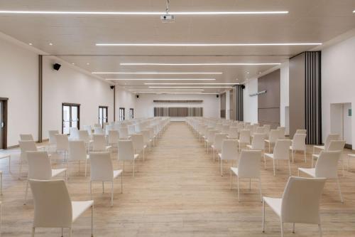 an empty room with white chairs and a large hall at Radisson Blu Resort Saidia Beach in Saidia 