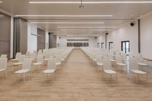 a room with rows of white chairs in it at Radisson Blu Resort Saidia Beach in Saidia 