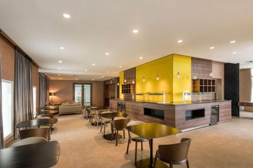 a restaurant with chairs and tables and a yellow kitchen at Radisson Blu Resort Saidia Beach in Saidia 