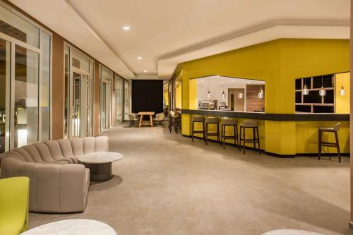 a lobby with a yellow wall and a bar at Radisson Blu Resort Saidia Beach in Saidia 