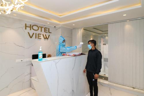 Ein Mann steht in einer Hotellobby mit einer Maske. in der Unterkunft Hotel View - A Boutique Hotel in Neu-Delhi