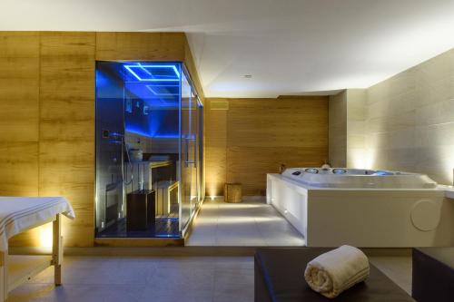 a large bathroom with a tub and a shower at Cumeja Beach Club & Hotel in Baia Domizia