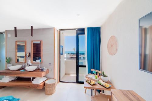 a bathroom with a sink and a mirror at Cumeja Beach Club & Hotel in Baia Domizia