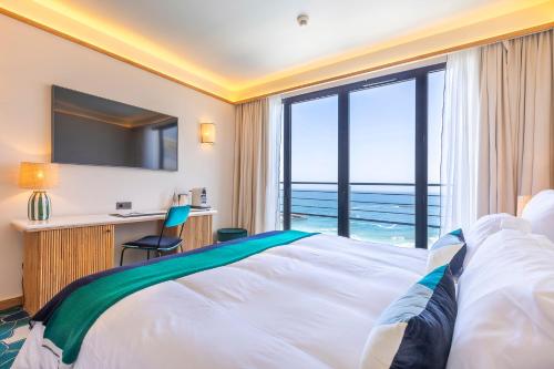 une chambre d'hôtel avec un lit et une vue sur l'océan dans l'établissement Hôtel Le Café de Paris, à Biarritz