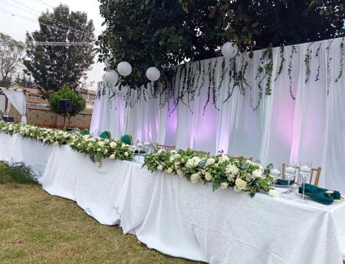 a long table with white flowers and white curtains at Ulwazi Place Hotel by Trianum in Nairobi