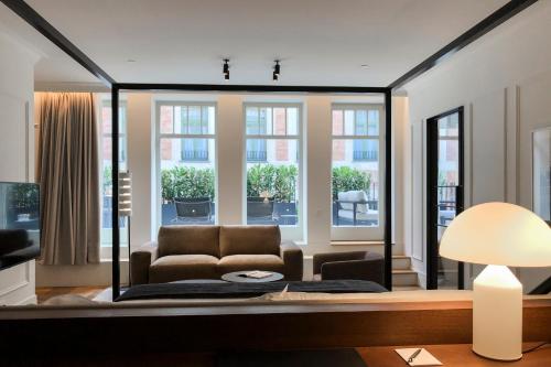 a living room with a couch and a large window at Kozmo Hotel Suites & Spa - Small Luxury Hotels of the World in Budapest