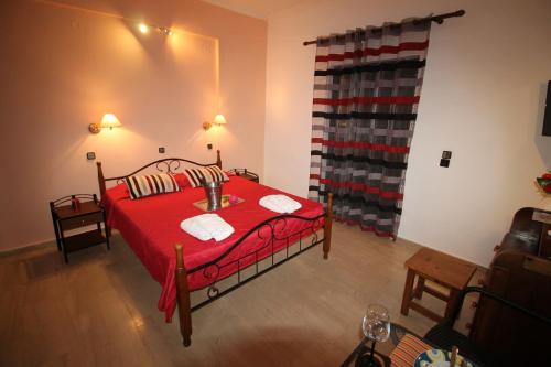 a bedroom with a red bed with a red blanket at Panorama in Agios Georgios