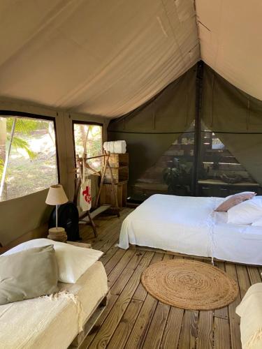 1 dormitorio con 2 camas en una tienda de campaña en Otentic, Eco Tent Experience, en Grande Rivière Sud Est
