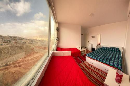 a room with two beds and a large window at Jordan Guest House in Wadi Musa