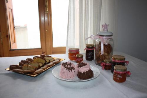 a table with a cake and pastries and jars of jam at Ξενώνας Ονειροπαγίδα in Arachova