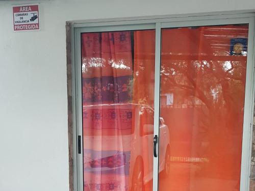 a glass door with a car in a window at La Quimera a pasos de la playa in Atlántida