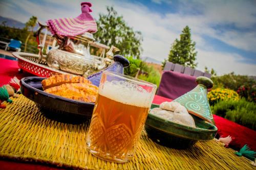 a glass of beer and a bowl of food on a table at Les Jardins Yasmina Bin el-Ouidane in Bine el Ouidane