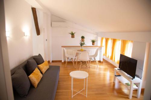 a living room with a couch and a table at RAJABAi in Almansa