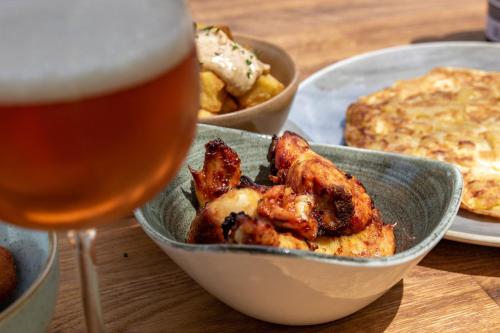 a bowl of food and a glass of beer at Hotel Esteba in Caldes de Malavella