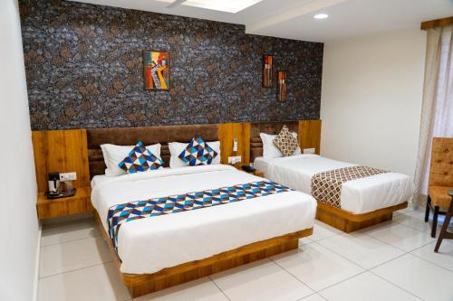 ein Hotelzimmer mit 2 Betten in einem Zimmer in der Unterkunft Hotel Lee Grand in Anand