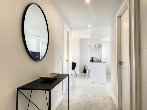 corridoio con tavolo nero e specchio di Via Celere 2331 Luxury Sea View Apartment a Bahia de Casares