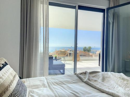 una camera da letto con un letto e vista sull'oceano di Via Celere 2331 Luxury Sea View Apartment a Bahia de Casares