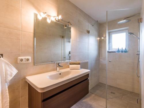 a bathroom with a sink and a shower with a mirror at Appartementhaus FICHTERN in Sankt Johann in Tirol