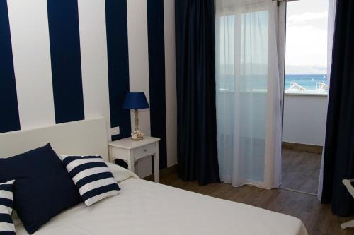 a bedroom with a bed and a view of the ocean at Hotel Nautilus in Cagliari