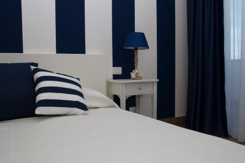 a bedroom with a bed with a blue and white stripes at Hotel Nautilus in Cagliari