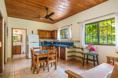 a kitchen with a table and a refrigerator at Guacamaya Lodge in Paraíso