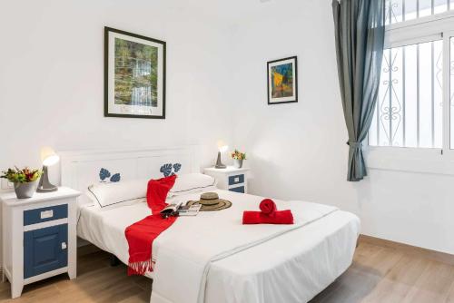 a white bedroom with two beds with red pillows at Las Vistas Cristianos by Welcome Tenerife in Los Cristianos