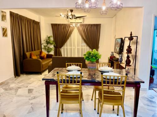 une table à manger et des chaises dans un salon dans l'établissement SEA LA VIE BATIK @ LAGUNA RESORT, à Port Dickson