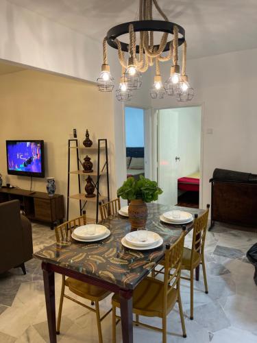 une table à manger avec des chaises et un lustre dans l'établissement SEA LA VIE BATIK @ LAGUNA RESORT, à Port Dickson