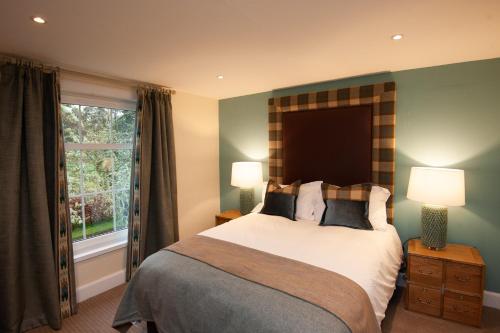 - une chambre avec un grand lit et une fenêtre dans l'établissement Parkside, The Loch Ness Cottage Collection, à Inverness