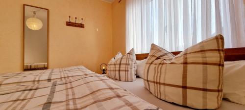 a bedroom with a bed with pillows and a window at Ferienhaus Antiquarius in Bendorf