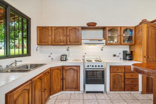 a kitchen with wooden cabinets and a stove top oven at Guacamaya Lodge in Paraíso