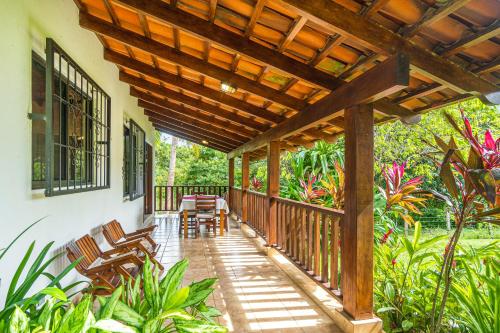 a wooden porch with chairs and a wooden pergola at Guacamaya Lodge in Paraíso