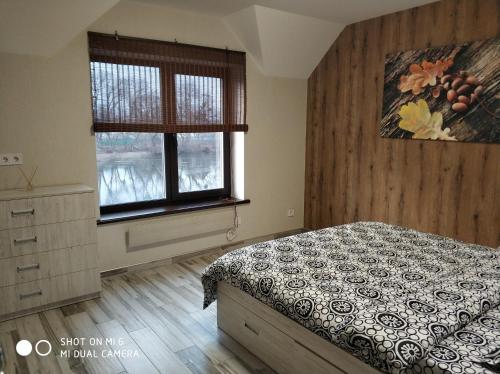 1 dormitorio con 1 cama y 2 ventanas en Home and SPA, en Kiev