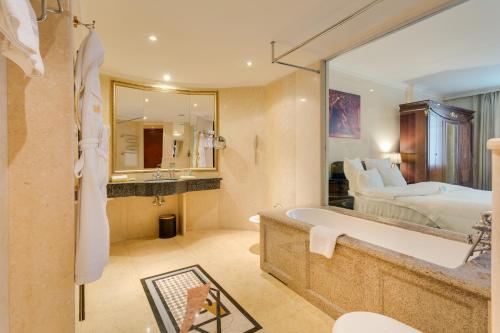 een badkamer met een bed en een bad in een kamer bij Golden Rooms Hotel in Moskou