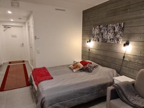 a bedroom with a large bed and a chair at LeviBooking Lost in Levi apt 305 in Kittilä