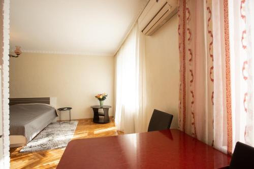 um quarto com uma mesa e uma cama num quarto em Уютная квартира в центре em Nikolayev