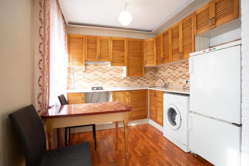 a kitchen with a table and a washing machine at Уютная квартира в центре in Mykolaiv