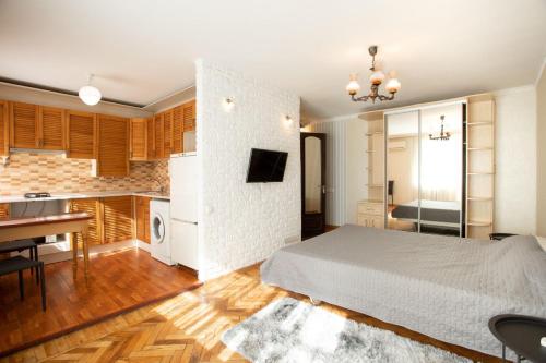 1 dormitorio con 1 cama blanca y cocina en Уютная квартира в центре, en Mykolaiv