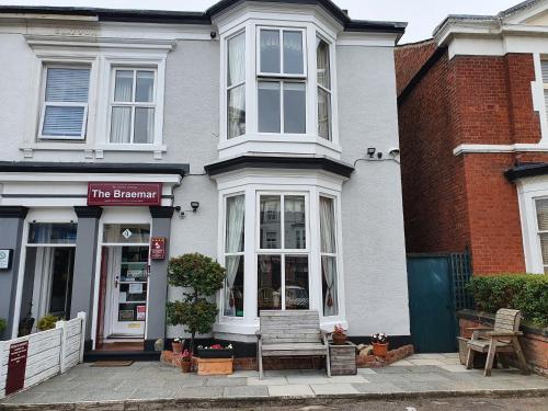 a building with a bench in front of a store at The Braemar Southport in Southport